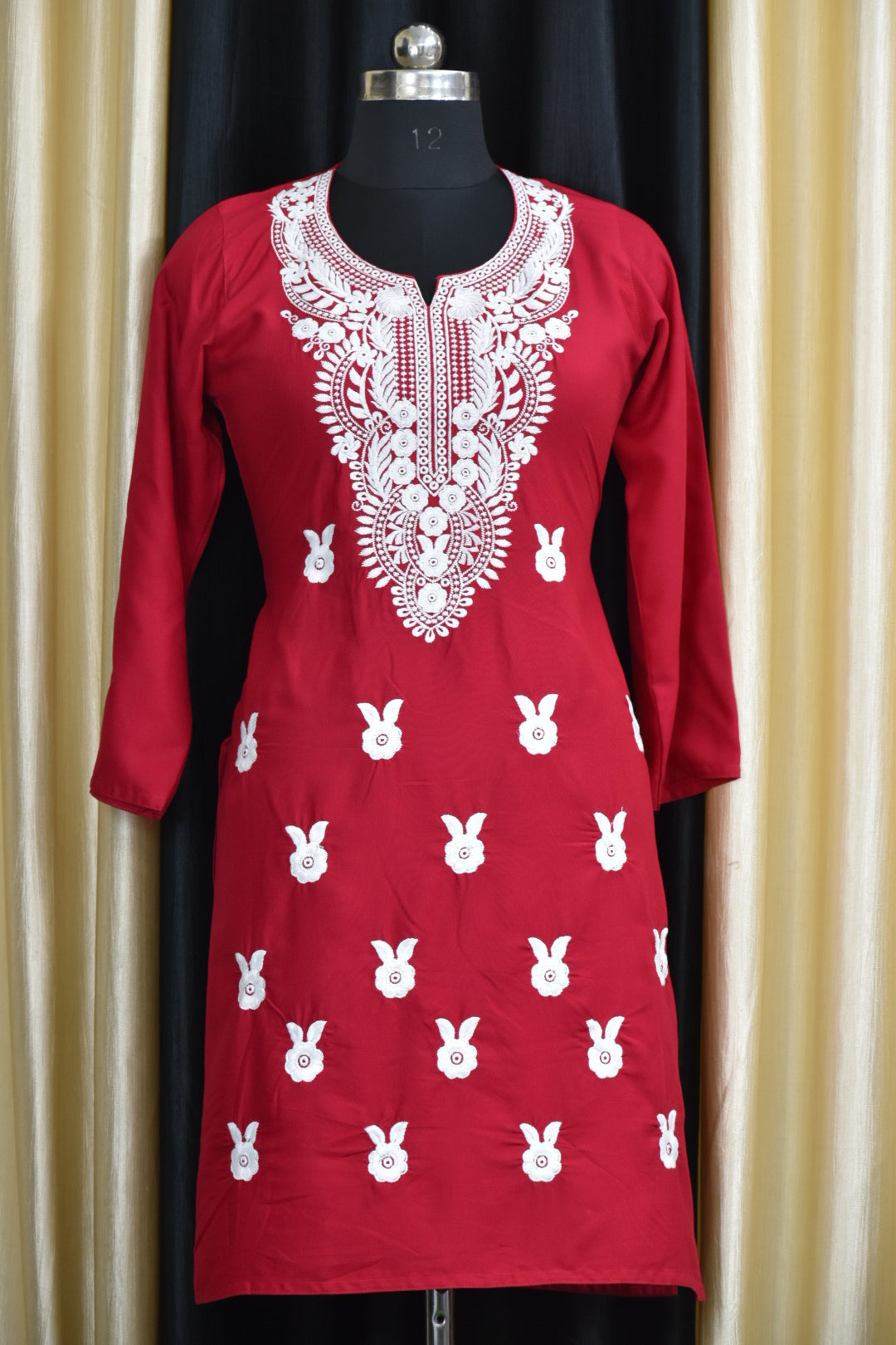 A-front-view-Vibrant maroon cotton kurti featuring intricate Chikankari embroidery, showcasing delicate floral patterns that add a traditional touch to a modern silhouette."