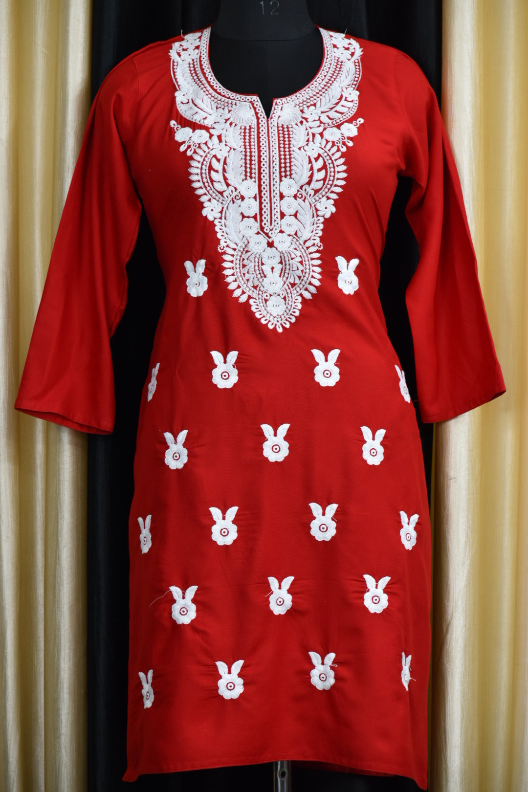 A-front-view-Vibrant red cotton kurti featuring intricate Chikankari embroidery, showcasing delicate floral patterns that add a traditional touch to a modern silhouette.