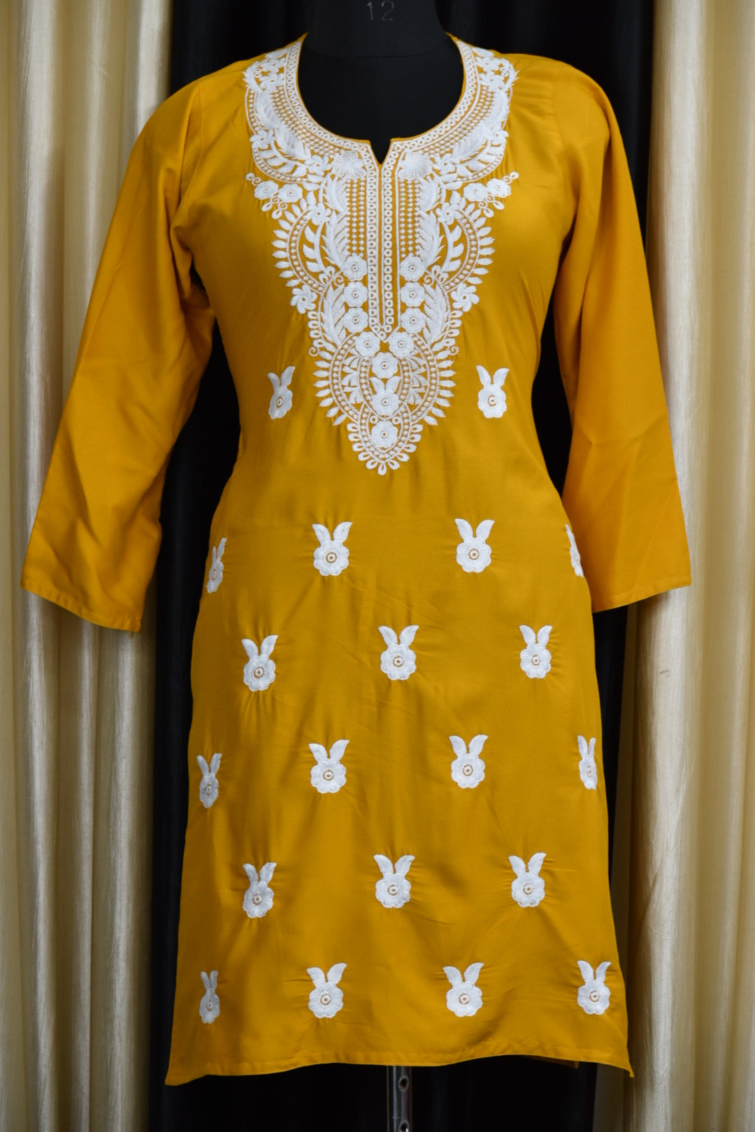 A-front-view-Vibrant yellow cotton kurti featuring intricate Chikankari embroidery, showcasing delicate floral patterns that add a traditional touch to a modern silhouette.