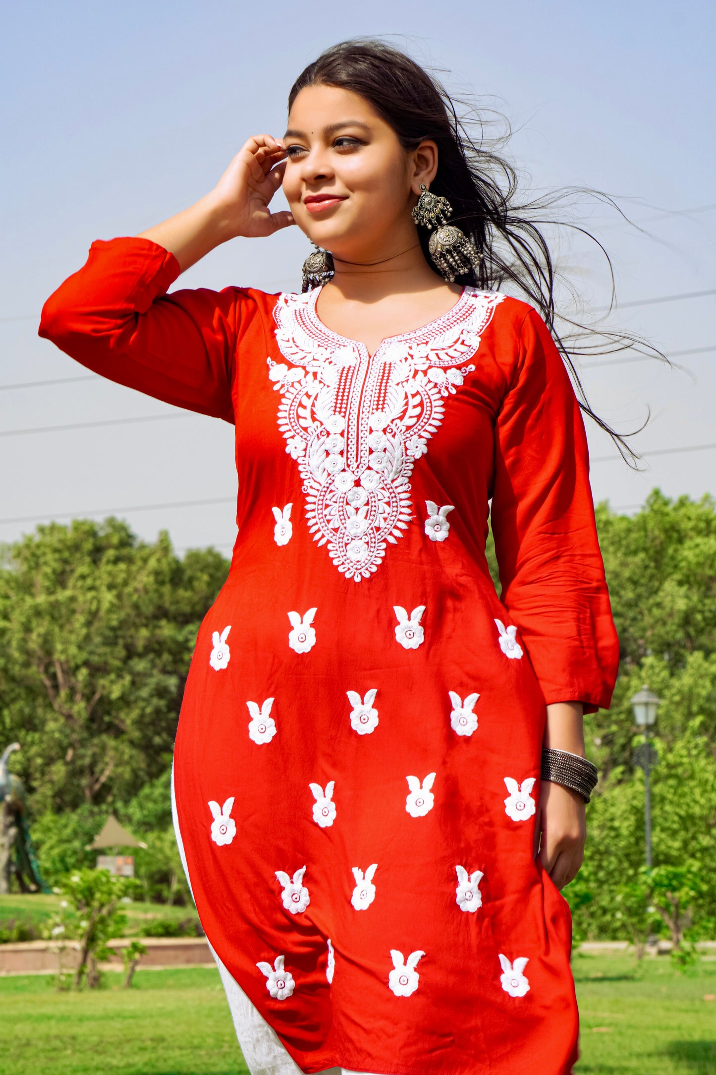 A-front-view-Vibrant red cotton kurti featuring intricate Chikankari embroidery, showcasing delicate floral patterns that add a traditional touch to a modern silhouette.