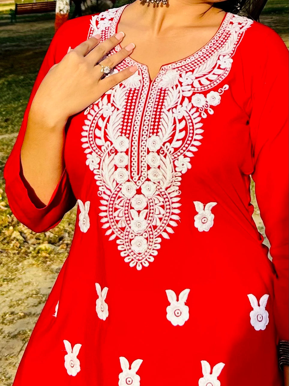 A-bottom-view-Vibrant red cotton kurti featuring intricate Chikankari embroidery, showcasing delicate floral patterns that add a traditional touch to a modern silhouette.
